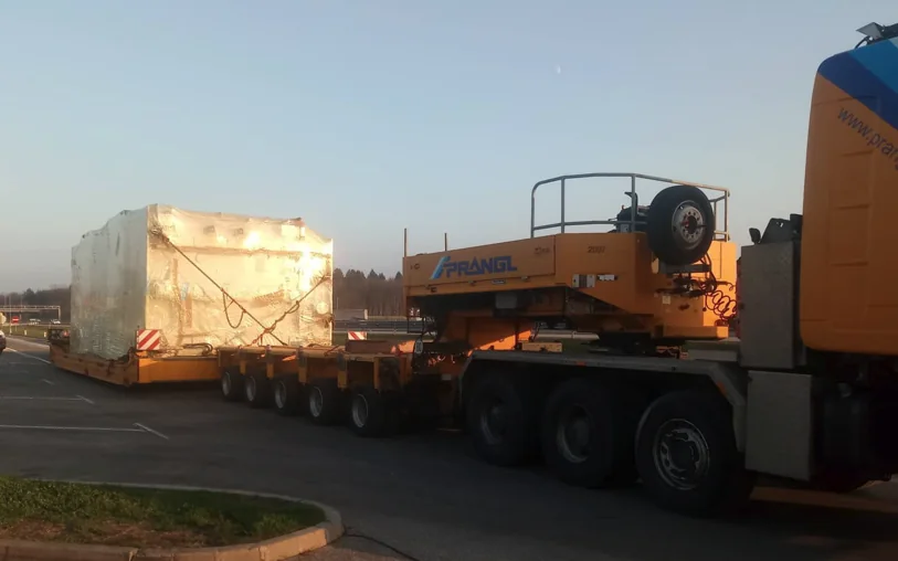 Tovornjak z nizkopodno prikolico prevaža velik zaščiten tovor izrednih dimenzij.